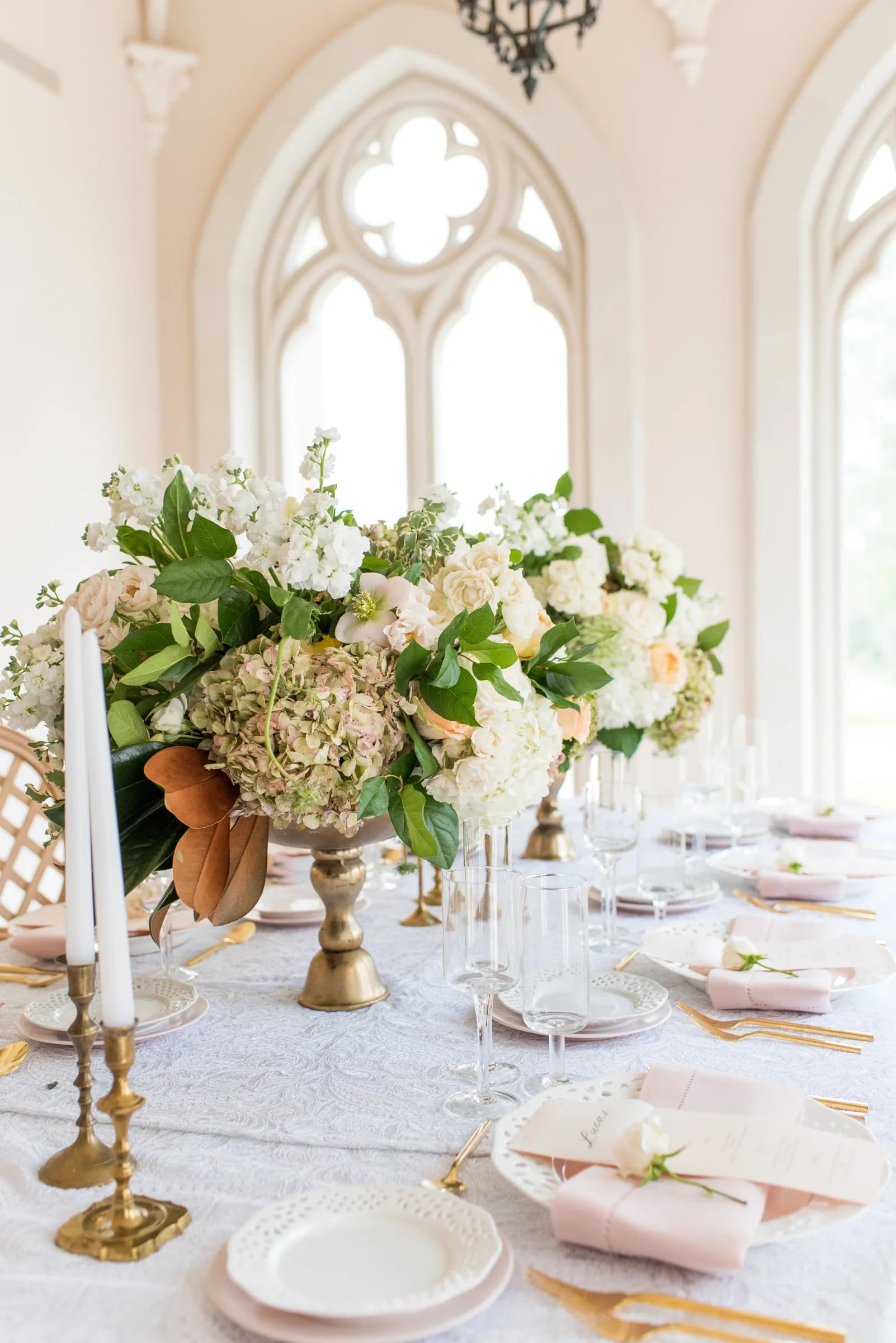 A beautifully arranged dining table adorned with elegant floral centerpieces, fine china, and soft pastel accents.