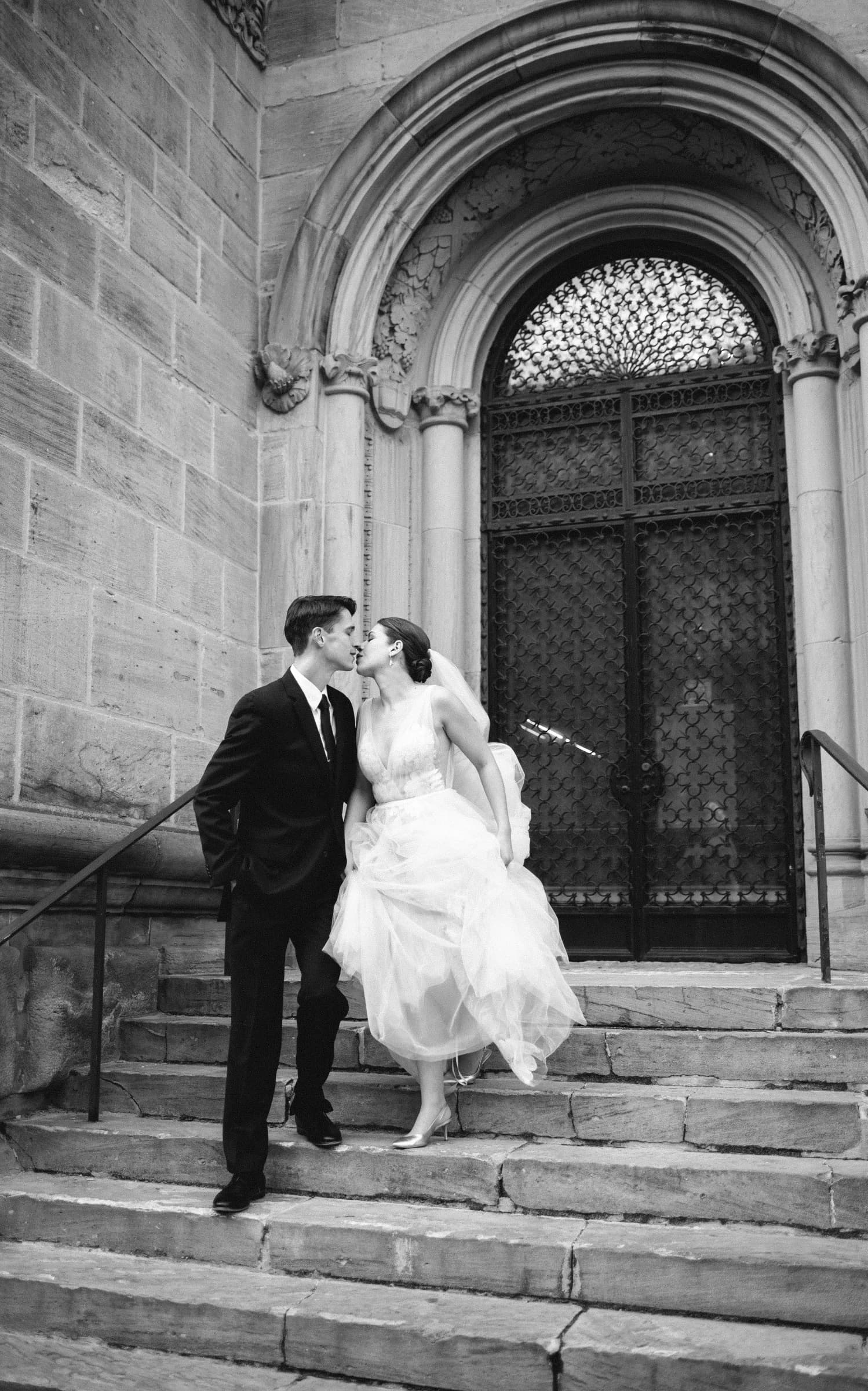 A bride in a beaded gown gazes through her veil in an elegant setting.